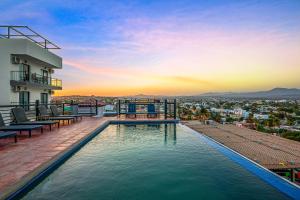 una piscina en la azotea de un edificio con puesta de sol en Morgan Residences 607, en Cabo San Lucas