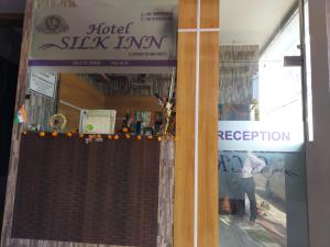 uma porta de um hotel deslizar pousada com uma pessoa na janela em Hotel Silk Inn Luxury At No Cost em Lucknow