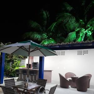 a table with an umbrella in front of chairs at Pousada Tartaruga in Cumbuco