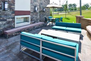un patio con sillas azules, mesa y chimenea en Hampton Inn Pittsburgh - Wexford - Cranberry South, en Wexford