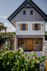 a house with wooden doors and a stone wall at Weinberg Chalet Kokumandl in Winten