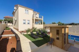 Elle offre une vue sur une maison dotée d'un jardin avec un barbecue. dans l'établissement Vila Marula, à Sevid