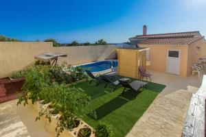 ein kleiner Hinterhof mit Pool, Stühlen und Terrasse in der Unterkunft Vila Marula in Sevid