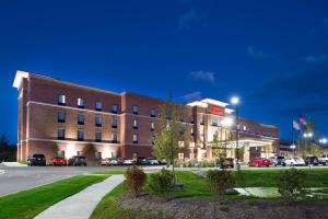 duży ceglany budynek z samochodami zaparkowanymi na parkingu w obiekcie Hampton Inn & Suites Ann Arbor West w mieście Ann Arbor