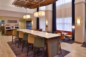 a lobby with a large bar with chairs at Hampton Inn & Suites Ann Arbor West in Ann Arbor