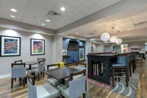 a restaurant with tables and chairs and a fireplace at Hampton Inn Emerson - Lakepoint, Ga in Cartersville