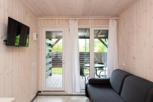 a living room with a couch and a sliding glass door at Vertikalė poilsio namai in Šventoji