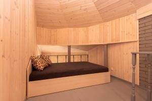 a room with a bed in a wooden cabin at Vertikalė poilsio namai in Šventoji