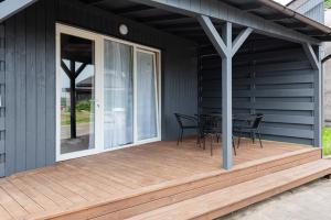 a deck with a table and chairs on a house at Vertikalė poilsio namai in Šventoji