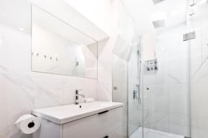 a white bathroom with a sink and a shower at Parc Avenue Hostel in Montreal