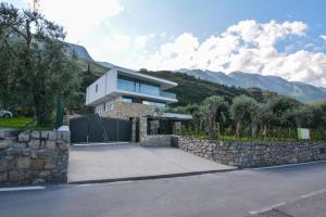uma casa com uma cerca de pedra e uma parede de pedra em Olivo Luxury Apartments em Malcesine