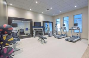 un gimnasio con cintas de correr, elípticas y espejos en Hampton Inn & Suites-Worcester, MA en Worcester