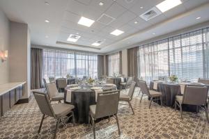 uma sala de conferências com mesas e cadeiras e janelas grandes em Hampton Inn & Suites-Worcester, MA em Worcester