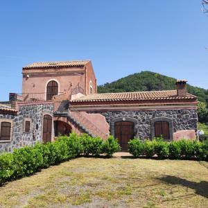 an old stone house with a staircase in a yard at Case Gemmellaro - Family&Friends in Nicolosi