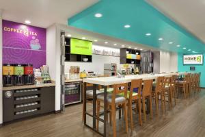 a coffee shop with a bar with wooden chairs at Home2 Suites by Hilton West Monroe in West Monroe