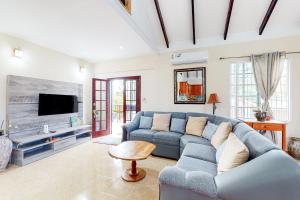 a living room with a blue couch and a tv at The Pine Tree Villa in San Ignacio