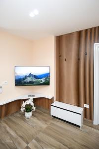 a living room with a tv on a wall at Queen Apartmets Vlore in Vlorë