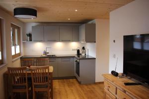 a kitchen with a table and a kitchen with a television at FeWo Fritz in Bad Hindelang