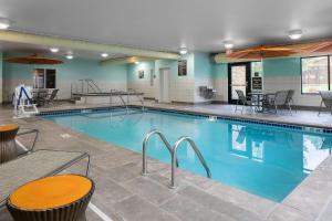 una piscina con mesas y sillas en un edificio en Hampton Inn & Suites Mason City, IA, en Mason City