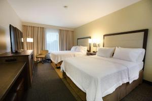 a hotel room with two beds and a flat screen tv at Hampton Inn & Suites Ponca City in Ponca City