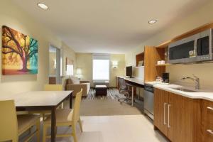 cocina y sala de estar con mesa y comedor en Home2 Suites by Hilton Alexandria, en Alexandria