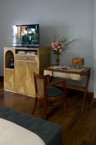 a living room with a tv and a chair and a table at Hub Porteño By Boutique Apartments BA in Buenos Aires
