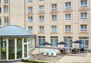 un bâtiment avec des tables et des chaises devant lui dans l'établissement Hilton Garden Inn Brussels City Centre, à Bruxelles