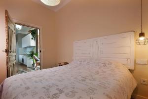 a bedroom with a large bed with a white bedspread at Casa el Tratado, situada en el casco histórico con patio privado in Tordesillas