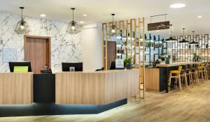 un vestíbulo de un restaurante con bar y sillas en Hilton Garden Inn Brussels City Centre en Bruselas