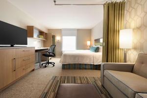 Pokój hotelowy z łóżkiem i biurkiem w obiekcie Home2 Suites by Hilton Milwaukee Brookfield w mieście Waukesha