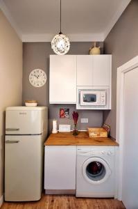 a kitchen with a refrigerator and a washing machine at Casa el Tratado, situada en el casco histórico con patio privado in Tordesillas