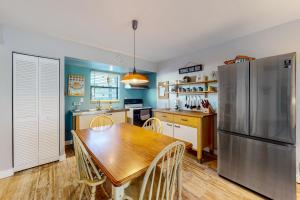a kitchen with a wooden table and a refrigerator at Angler's Dream in Marco Island