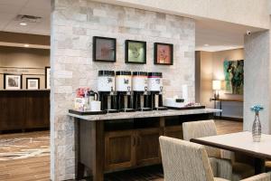 Hampton Inn & Suites-Hudson Wisconsin في هدسون: بار به زجاجات النبيذ على جدار حجري