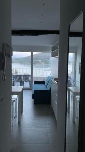 een woonkamer met een bank en een keuken met uitzicht bij Seafront rooftop flat w/ terrace in Portovenere