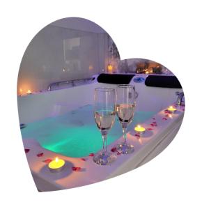Vip apartment for lovers in Chisinau في كيشيناو: كأسين من النبيذ على طاولة بجوار حمام سباحة