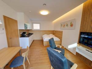a small room with a table and chairs and a bed at 6bits Apartments in Jeseník