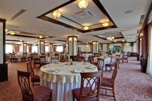un salón de banquetes con mesas y sillas blancas en DoubleTree by Hilton Hotel Sighisoara - Cavaler, en Sighişoara