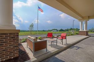 a patio with two chairs and a table and an american flag at Hampton Inn & Suites Cazenovia, NY in Cazenovia