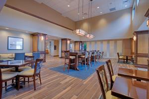 uma sala de jantar com mesas e cadeiras de madeira em Hampton Inn & Suites Cazenovia, NY em Cazenovia