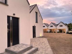 uma casa branca com uma porta preta num quintal em Apartamenty Lawendowy Zakątek em Władysławowo