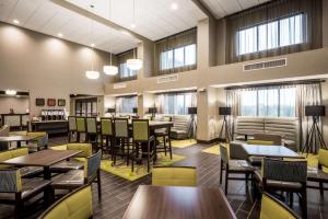 - une salle à manger avec des tables, des chaises et des fenêtres dans l'établissement Hampton Inn & Suites By Hilton Hammond, In, à Hammond