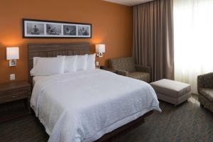 una camera d'albergo con un letto grande e una sedia di Hampton Inn by Hilton Irapuato a Irapuato