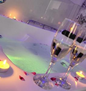 Vip apartment for lovers in Chisinau في كيشيناو: كأسين من النبيذ يجلسون على طاولة مع حوض استحمام