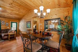 uma sala de jantar e sala de estar num chalé de madeira em EASY LIVIN - SECLUDED FAMILY LOG CABIN em Sevierville