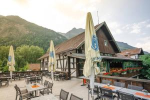un ristorante con tavoli, sedie e ombrelloni di Mountain Chalet on Gut Buchwies a Oberau
