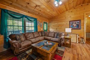 a living room with a couch and a coffee table at EASY LIVIN - SECLUDED FAMILY LOG CABIN in Sevierville