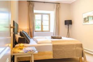 um quarto com uma cama, uma mesa e uma janela em Mountain Chalet on Gut Buchwies em Oberau