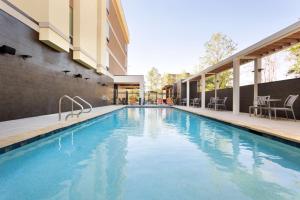 a pool at a hotel with chairs and tables at Home2 Suites by Hilton Shenandoah The Woodlands in The Woodlands