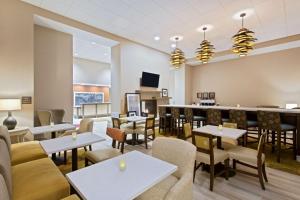 a restaurant with tables and chairs and a bar at Hampton Inn Sault Ste Marie, MI in Sault Ste. Marie