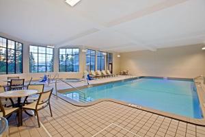 una piscina en una habitación de hotel con mesa y sillas en Hampton Inn Sault Ste Marie, MI, en Sault Ste. Marie